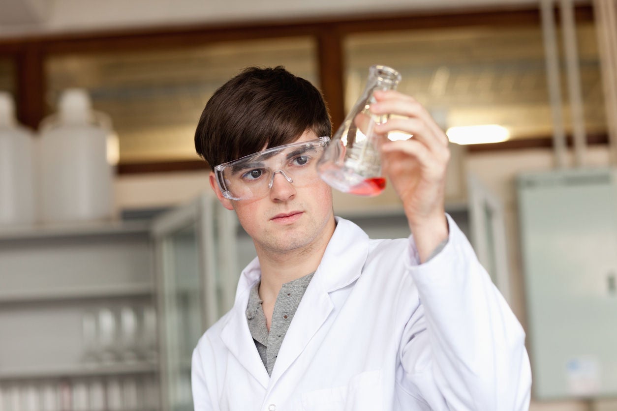 Scientist looking at a liquid in an Erlenmeyer flask in a laboratory